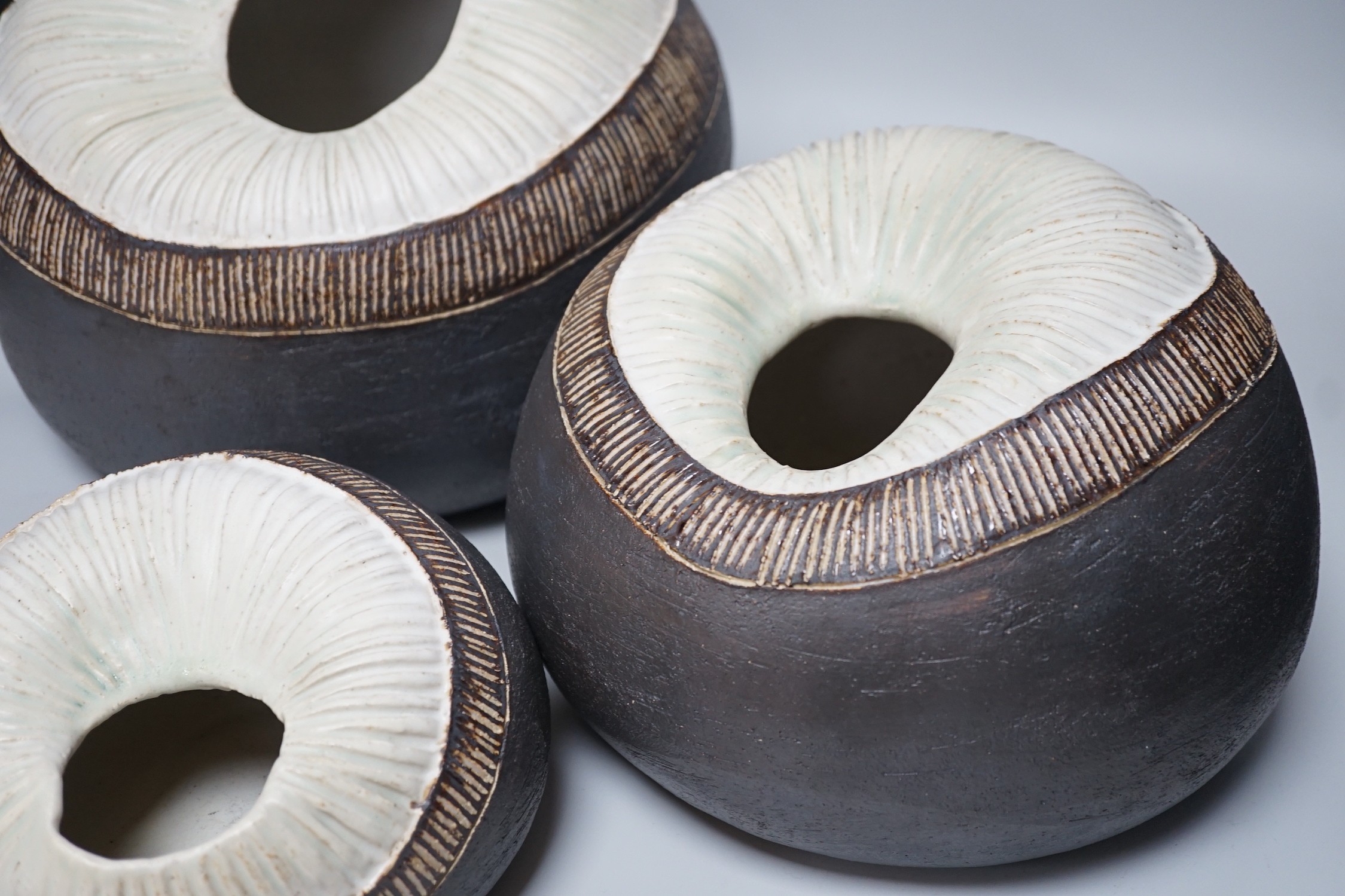 Ruth Sulke - a set of three graduated shell-like circular pottery vases, each inscribed R/S on base, tallest approximately 25cms high